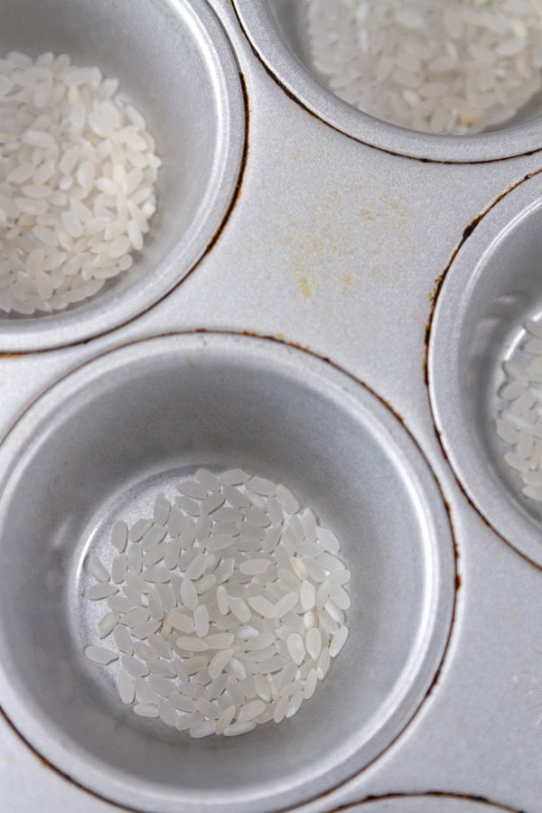 rice at the bottom of a muffin pan.