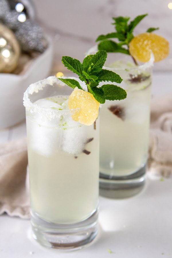two iced drinks in front of a cloth napkin and a bowl of ornaments.