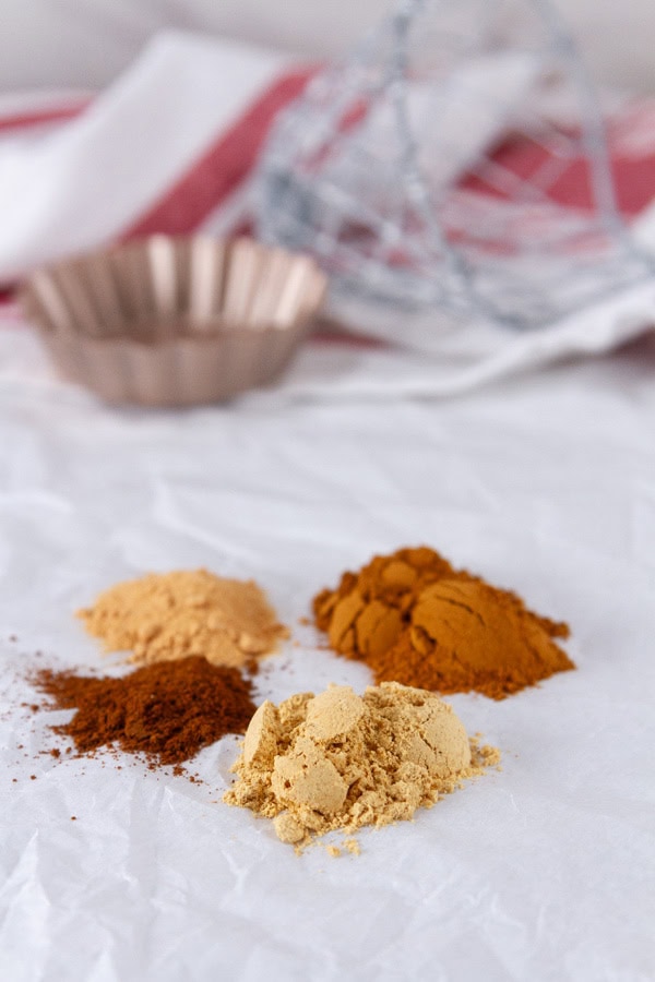 spices on a piece of parchment paper with baking tools in the background.