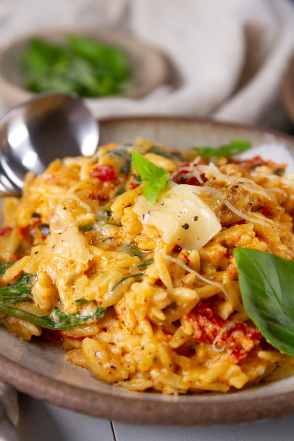 close up on a serving of baked orzo with cheese and veggies.