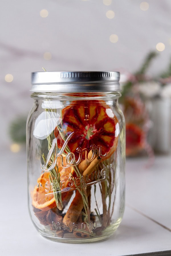 a mason jar filled with dried fruits, herbs and spices to simmer on the stove.
