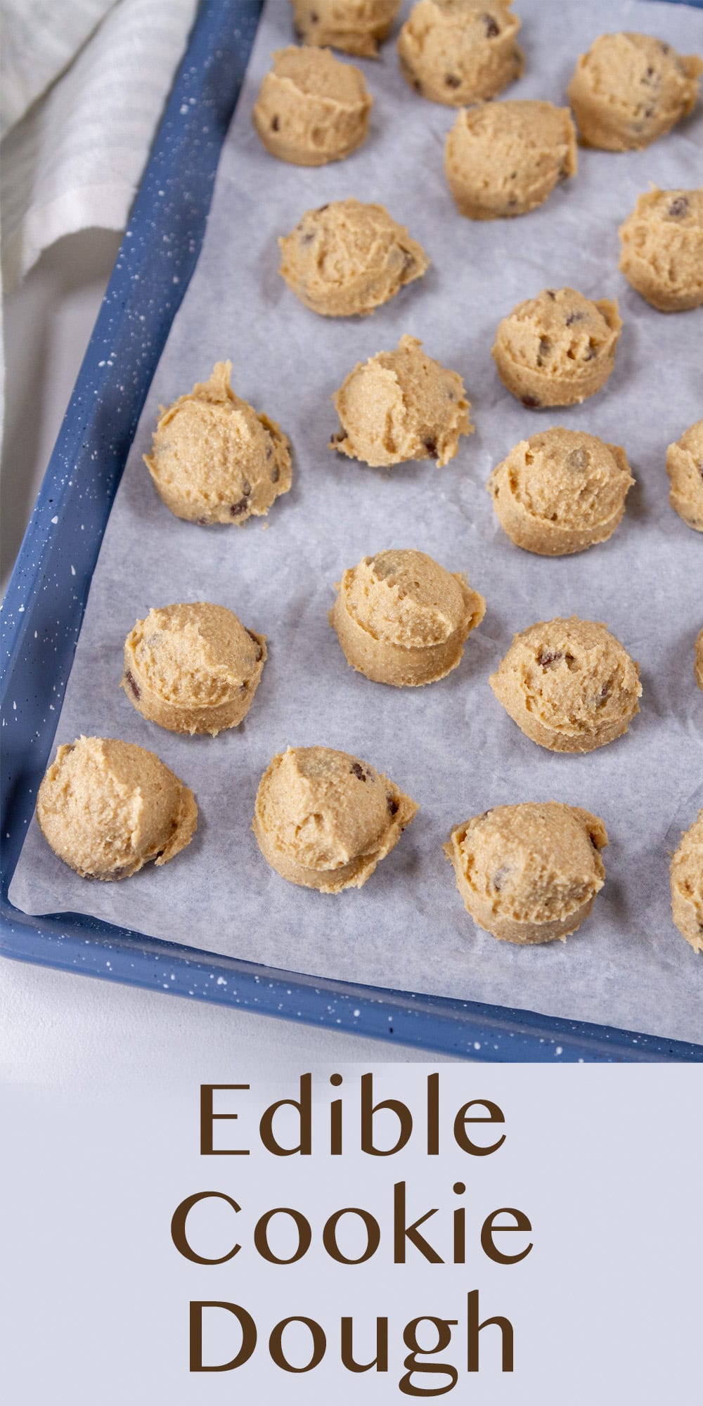 a blue tray lined with parchment paper with cookie dough balls on it.