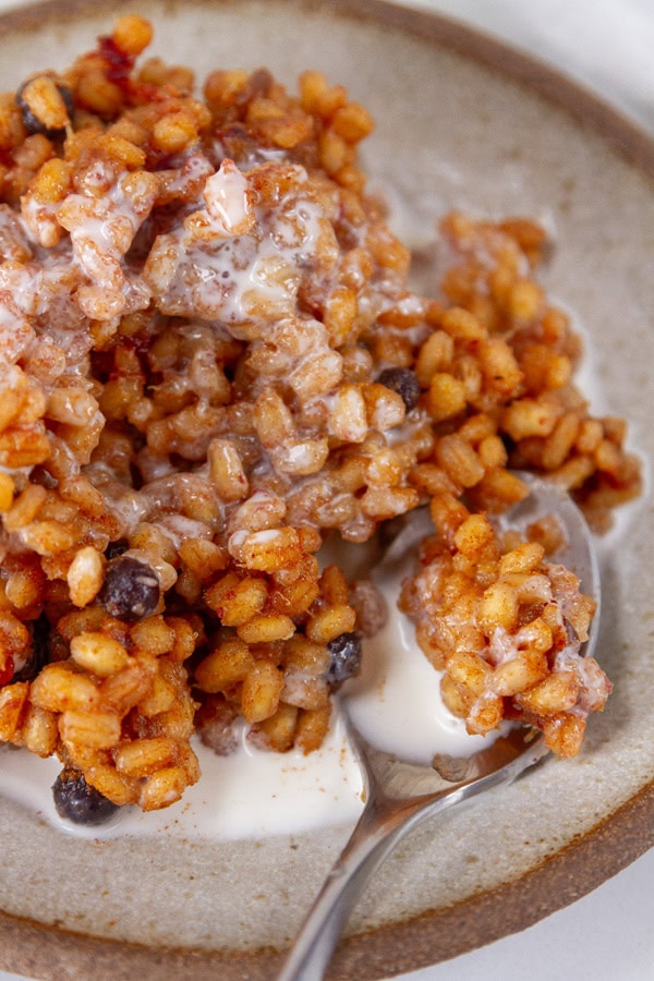 looking down into a bowl with barley with milk on it.
