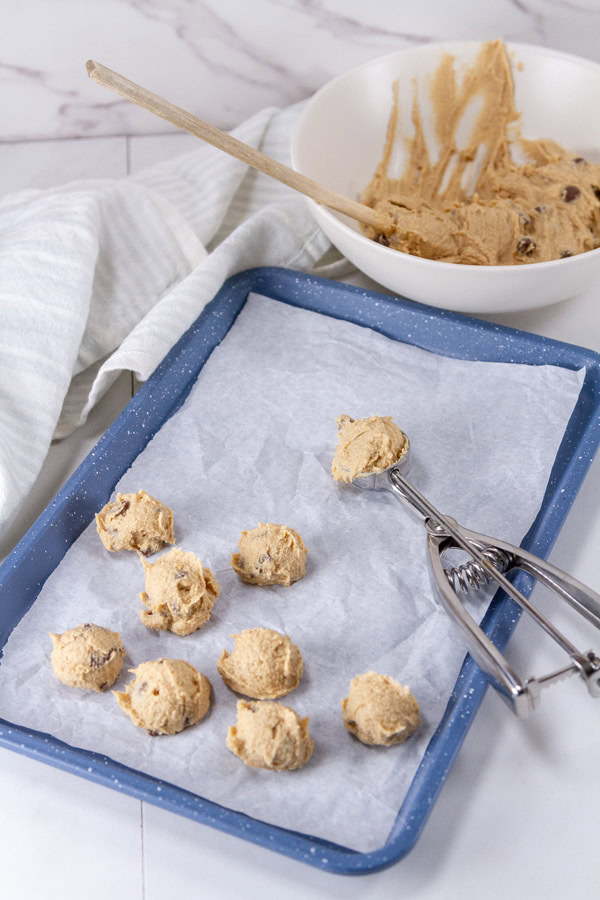 scooping cookie dough into bite sized treats.