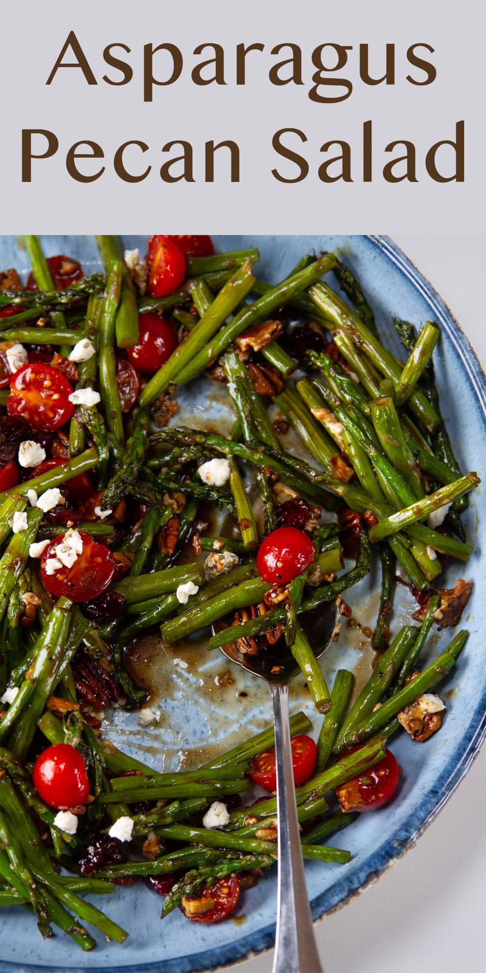 looking down into a blue serving bowl with vegetables in it and a spoon.