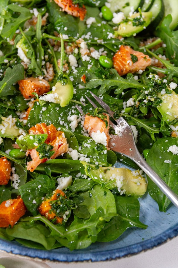 close up on a big salad with a fork in the lower right.