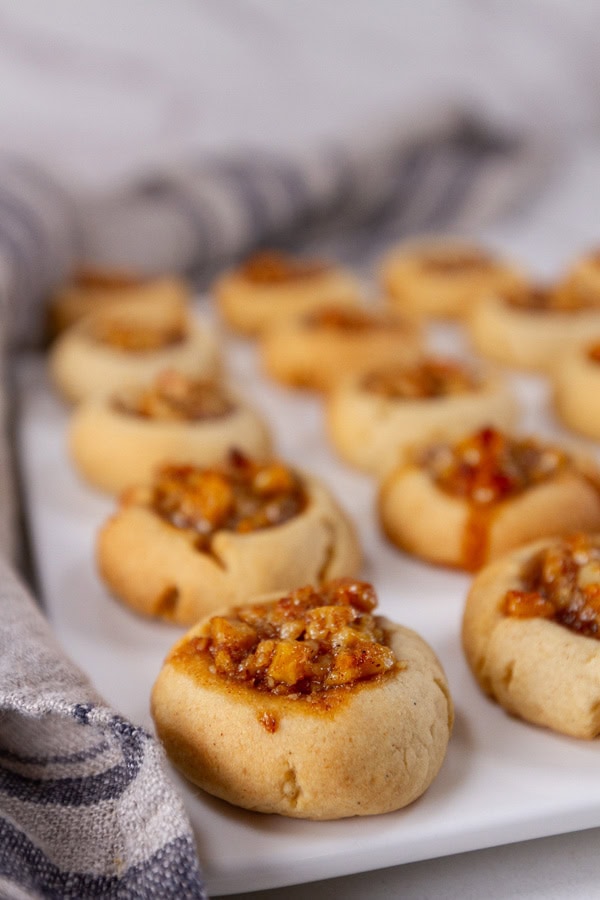 cookies on a white serving plate with a blue cloth napkin near.