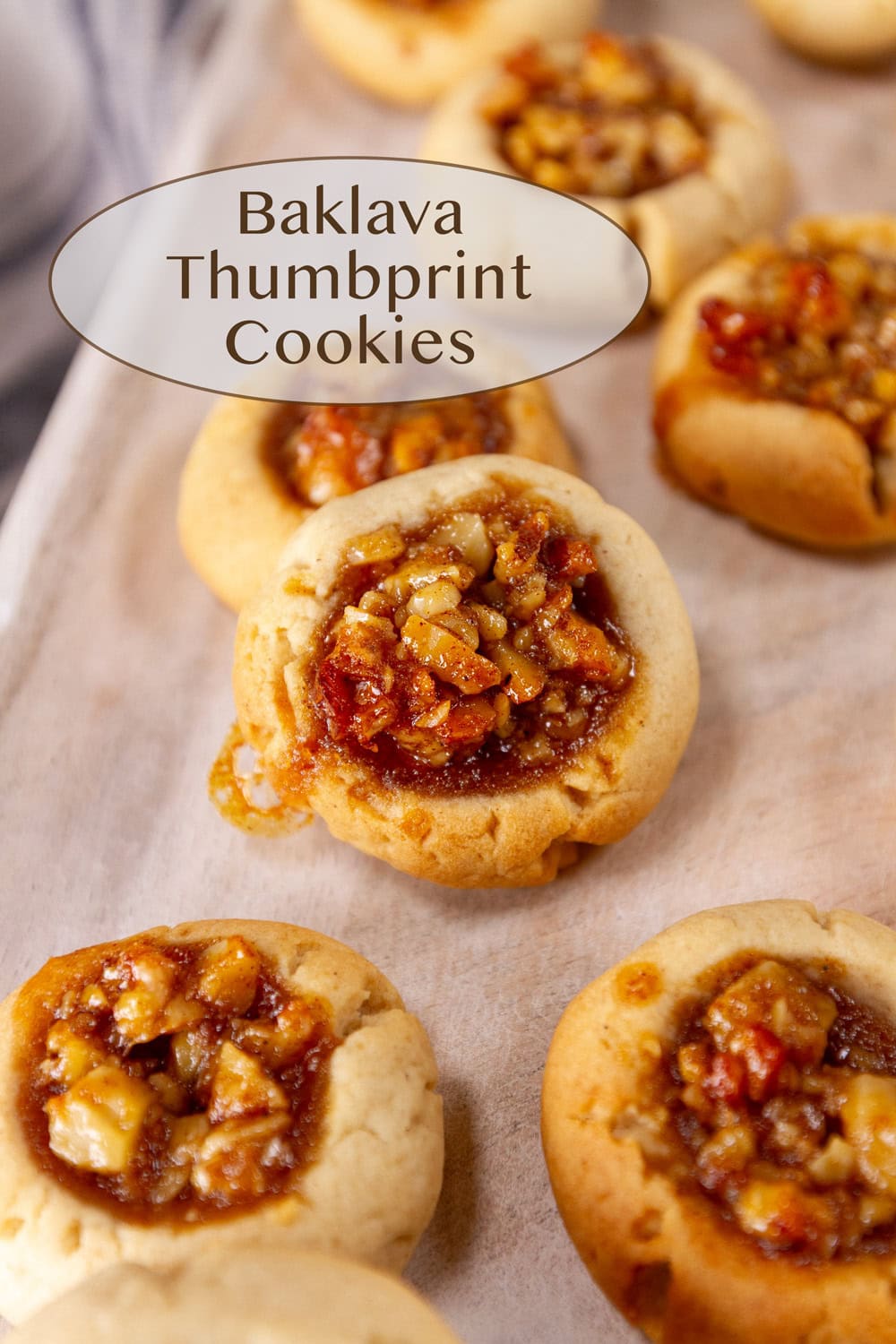 Baklava Thumbprint Cookies on a wooden tray.
