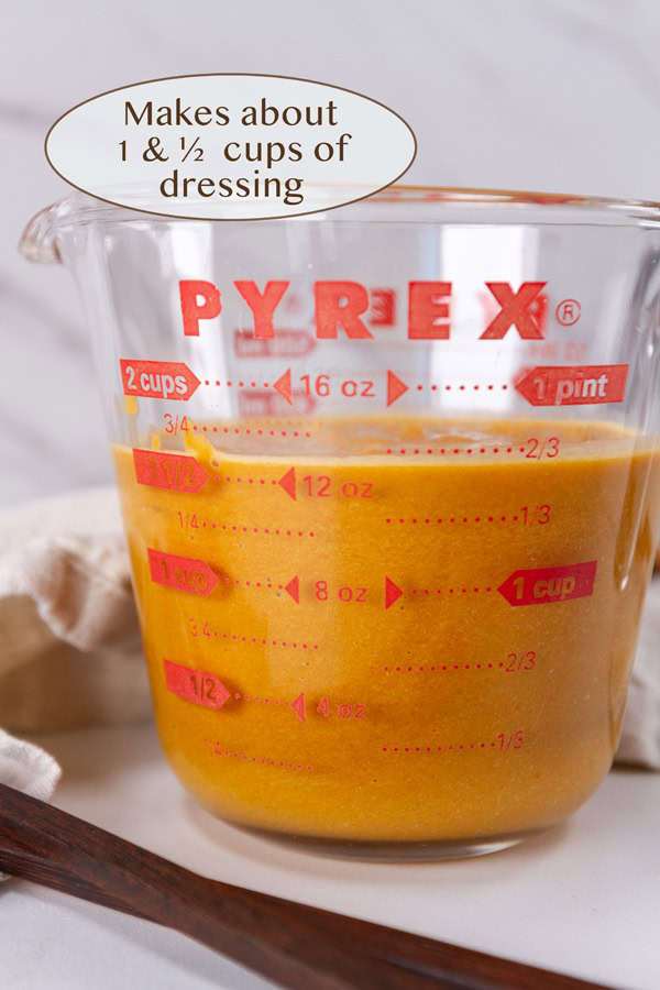 a glass measuring cup with dressing in it.
