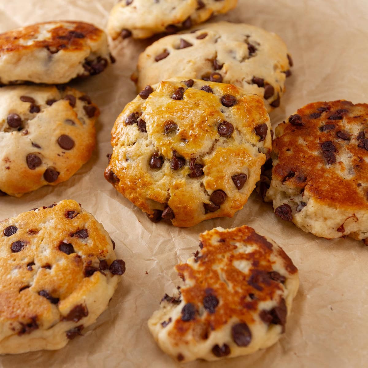 square crop of biscuits piled up on a piece of parchment paper.