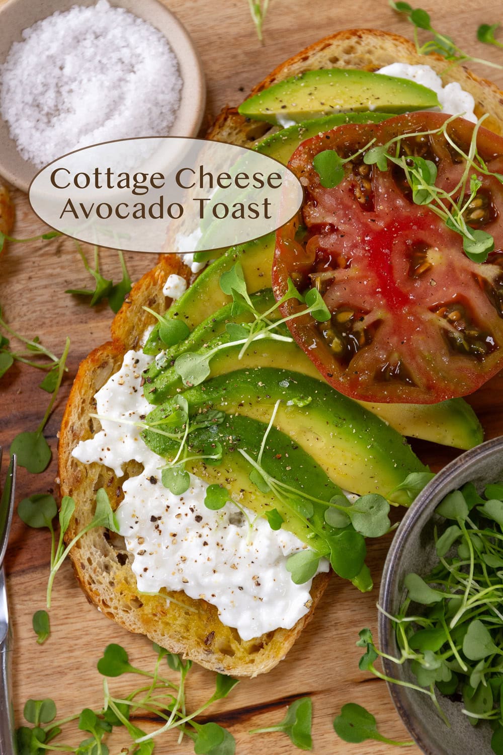 a piece of avocado toast with cottage cheese and a slice of tomato.