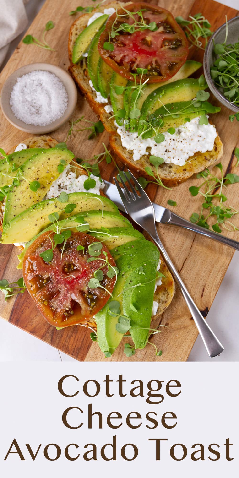 two slices of toast with avocado, cottage cheese, tomato on a wooden cutting board.