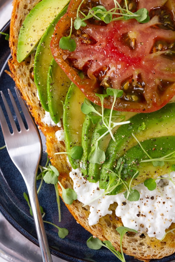 close up on avocado toast with a fork to the left.