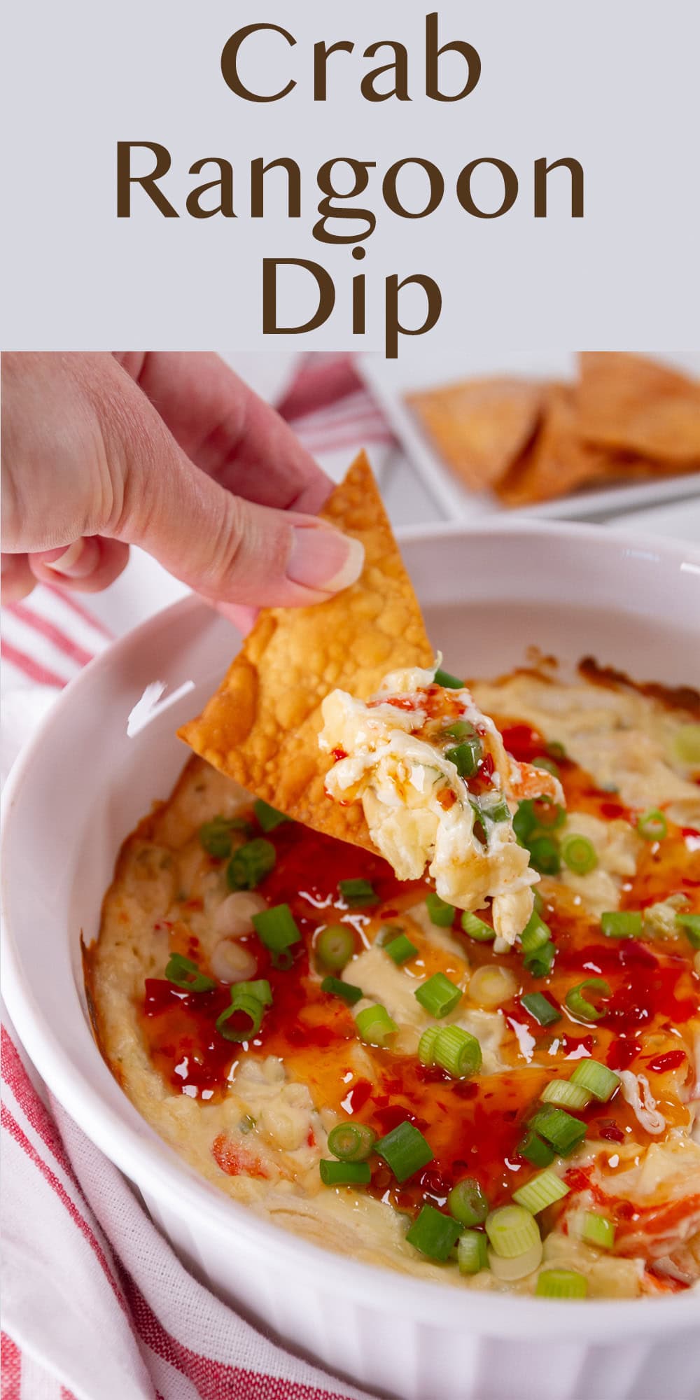 a wonton chip dipped into Crab Rangoon Dip by a hand.