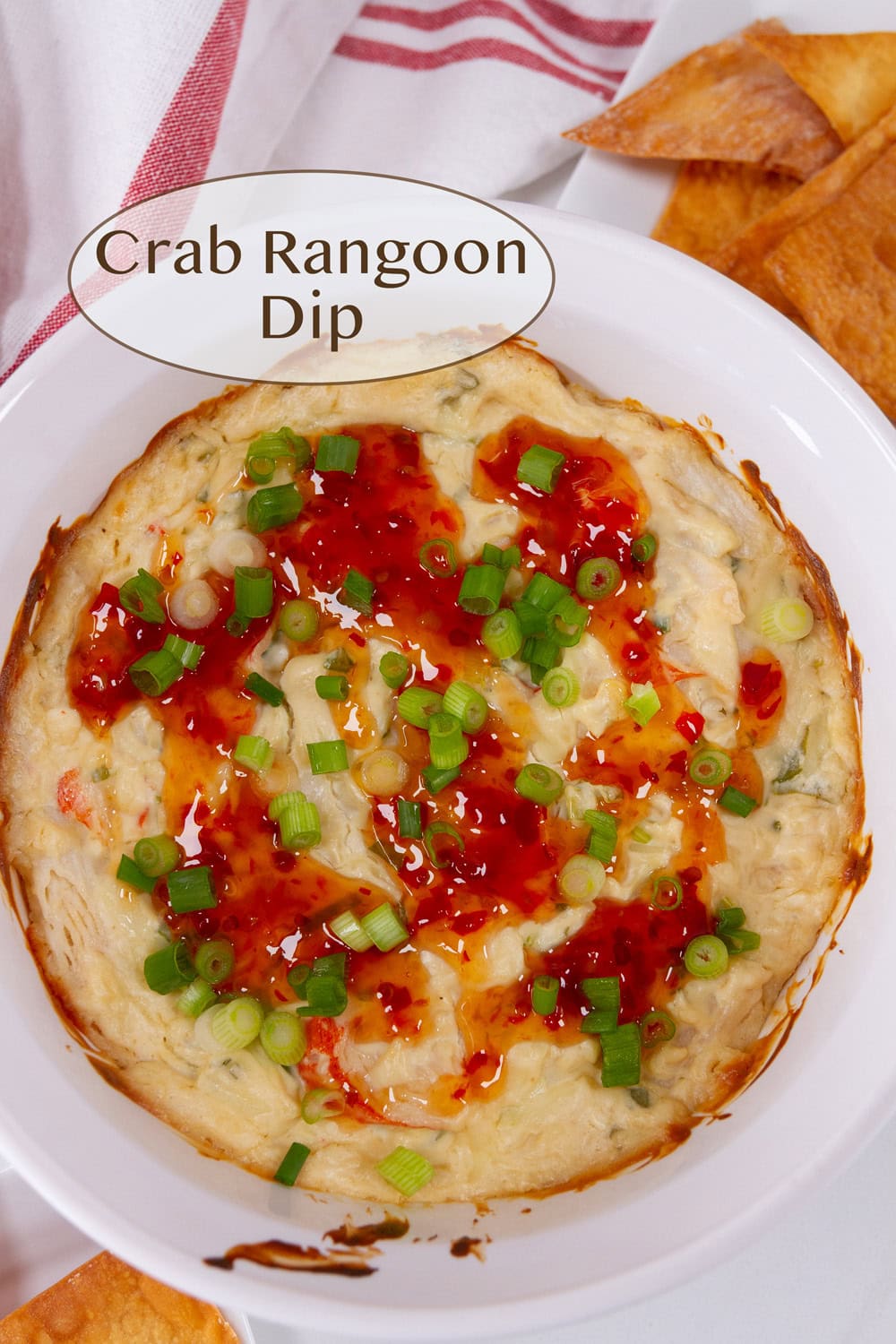 looking down into a baking dish filled with crab dip and topped with sweet chili sauce.