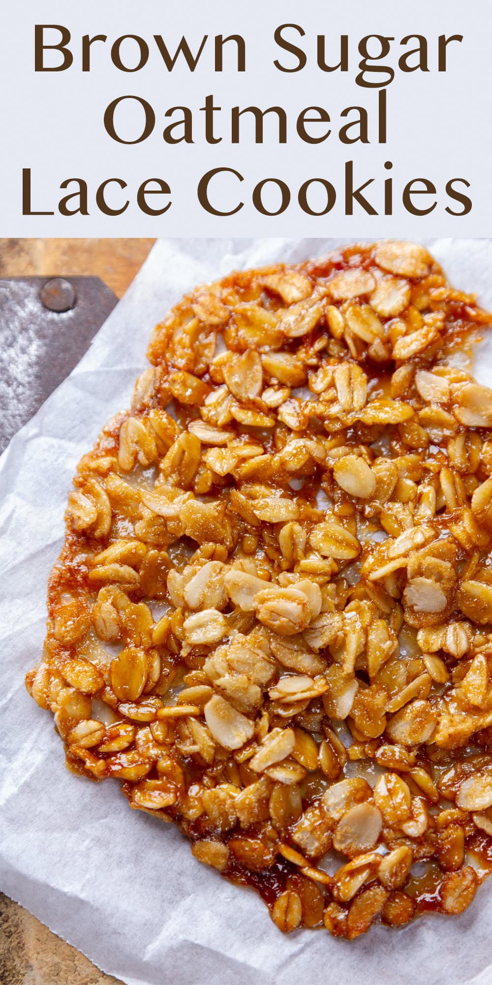 close up of a cookie with oatmeal in it on a piece of white parchment paper.