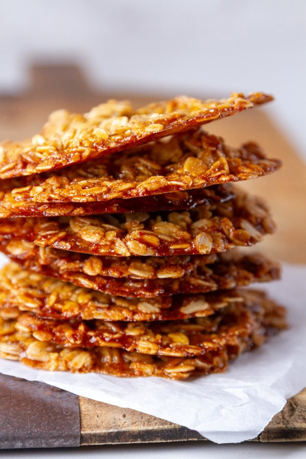 a stack of lace cookies on a piece of parchment paper.