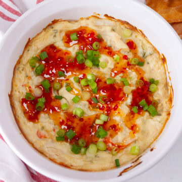 square cup of a baked crab Rangoon dip with sweet chili sauce.