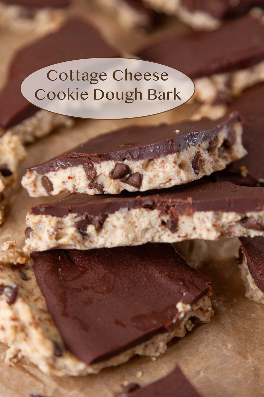 Pieces of cookie dough bark topped with chocolate stacked up.