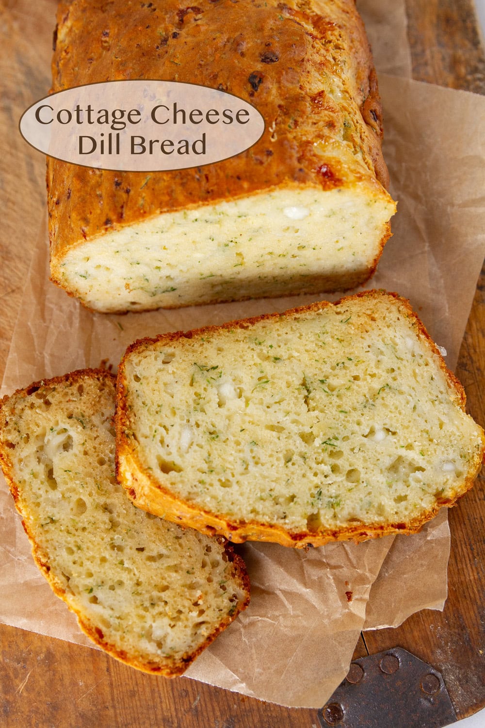 a loaf of homemade bread that's been sliced and it's on a wooden cutting board.