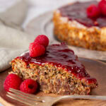 square crop of a slice of cake with a fork in front of the whole cake.