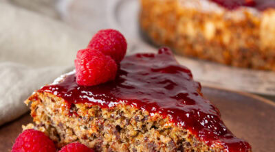 square crop of a slice of cake with a fork in front of the whole cake.