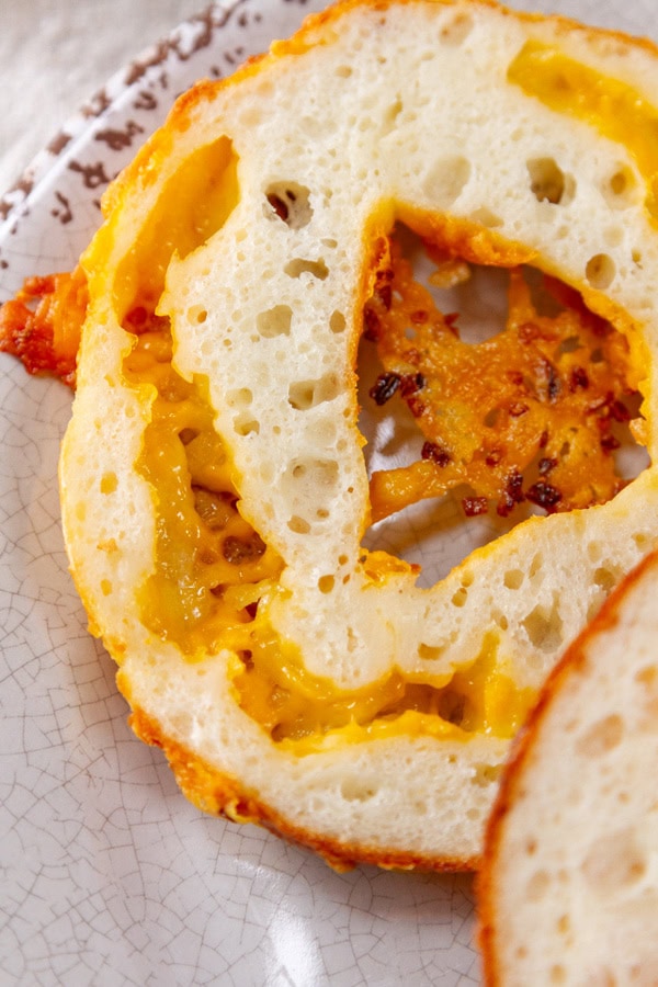 a cut open bagel showing the inside cheese ribbon.