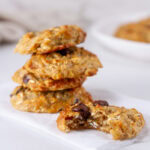 square crop of a stack of chocolate chip cookies with one to the right with a bite taken out of it.