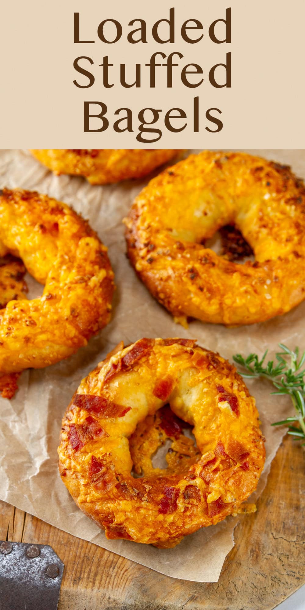 looking down on some bagels on a piece of parchment paper with some rosemary.