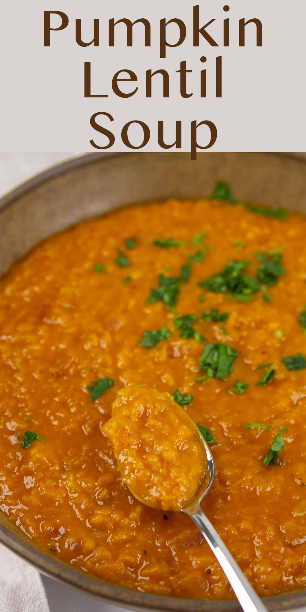 a spoon taking a bite out of a bowl of soup.