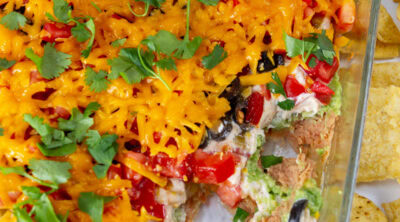 square crop of layered bean dip in a pan.