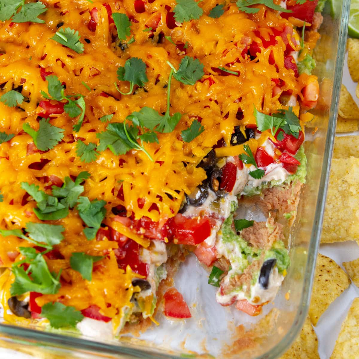 square crop of layered bean dip in a pan.