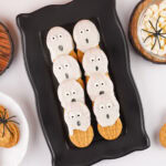 square crop of Halloween cookies on a black tray.