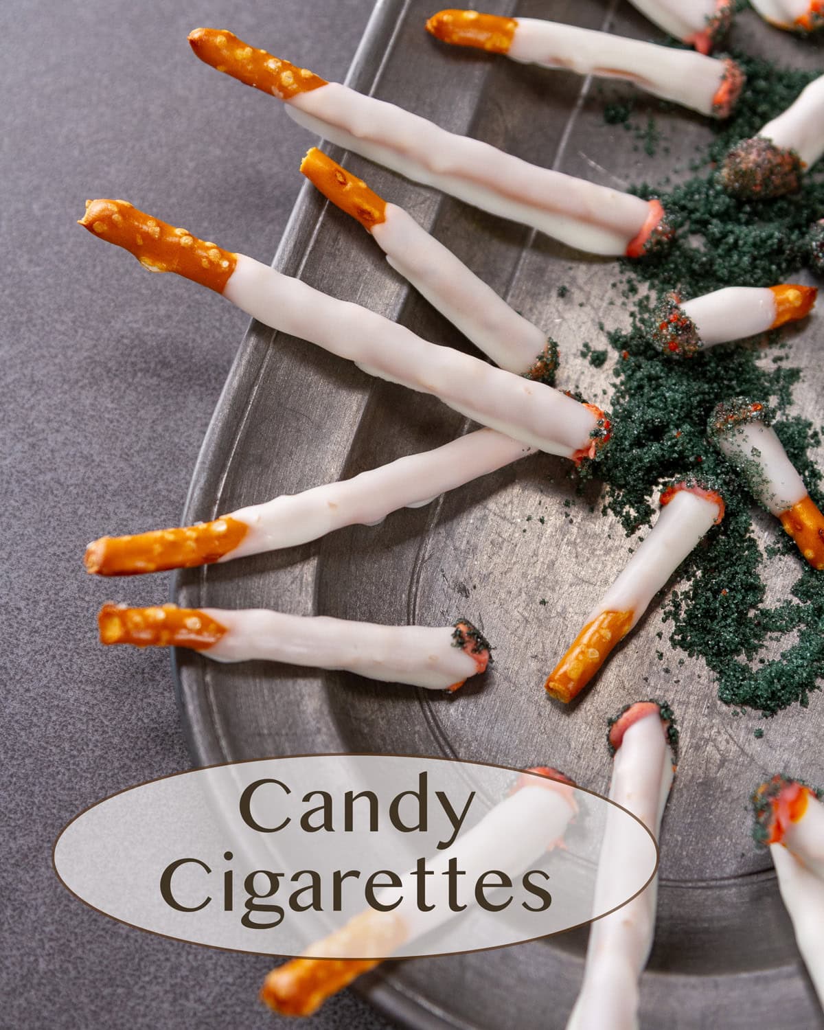 edible candy cigarettes for Halloween made from pretzels on a pewter plate.