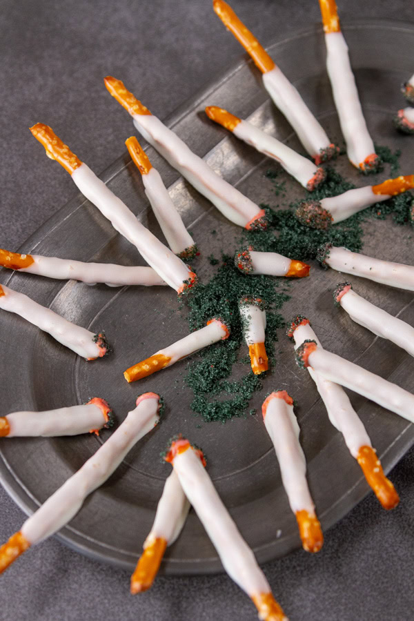 a pewter plate with lots of candy cigarettes on it.