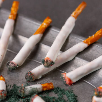 square crop of pretzel cigarettes on a plate.