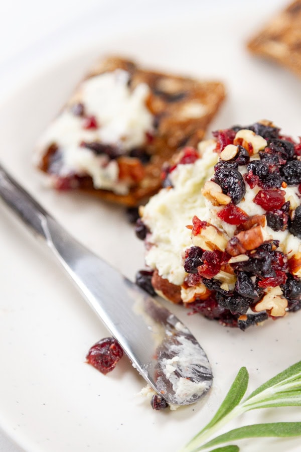 blue cheese appetizer bite and a cracker with a spreader knife.