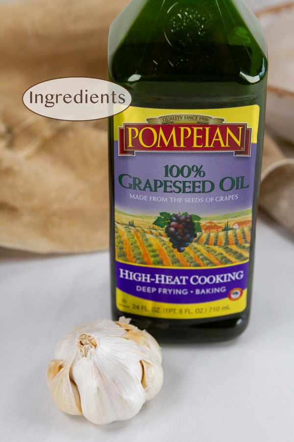 a head of garlic and a bottle of oil.