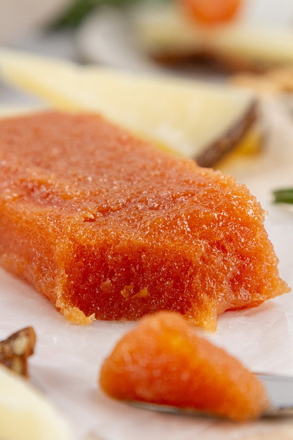 close up on a block of quince paste with manchego cheese in the background.