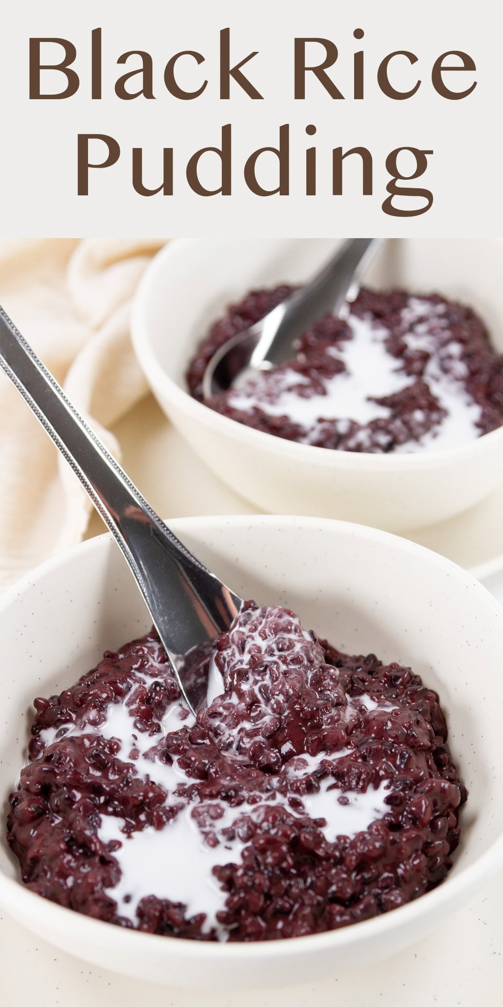 two bowls of rice pudding made with black rice, both with spoons in them.
