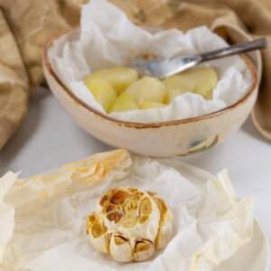 square crop of a head of roasted garlic and a dish or roasted elephant garlic.