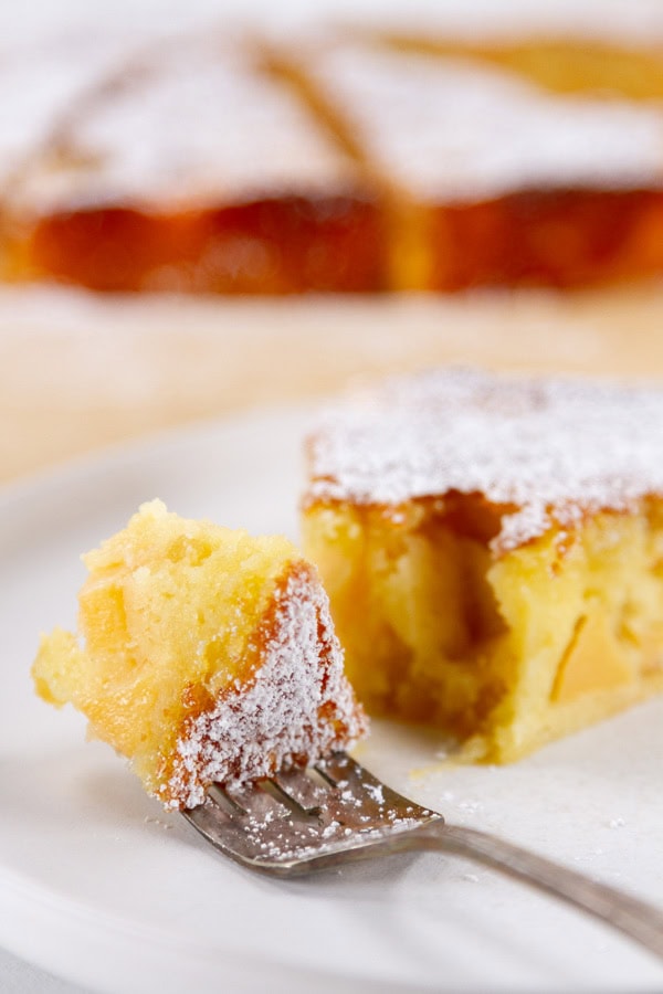 A fork full of cake on a plate.