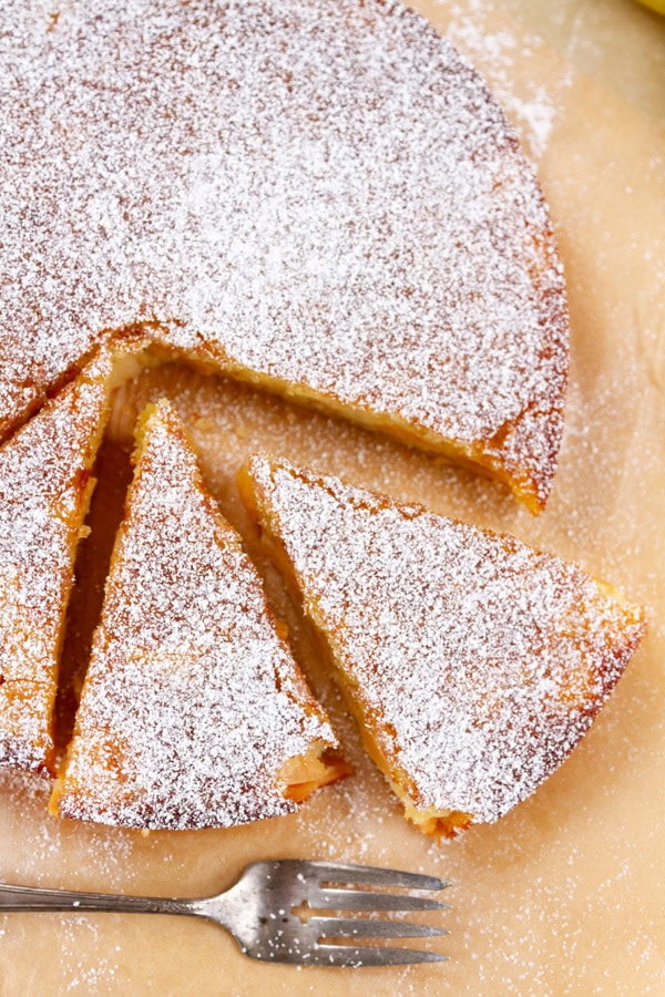 looking down on a cake that's been sliced with a fork next to it.