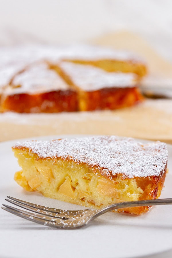 the side of a slice of cake on a white plate with a fork.