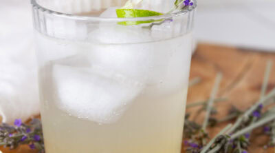 square crop of a glass or iced lavender Collins with sprigs of lavender around.
