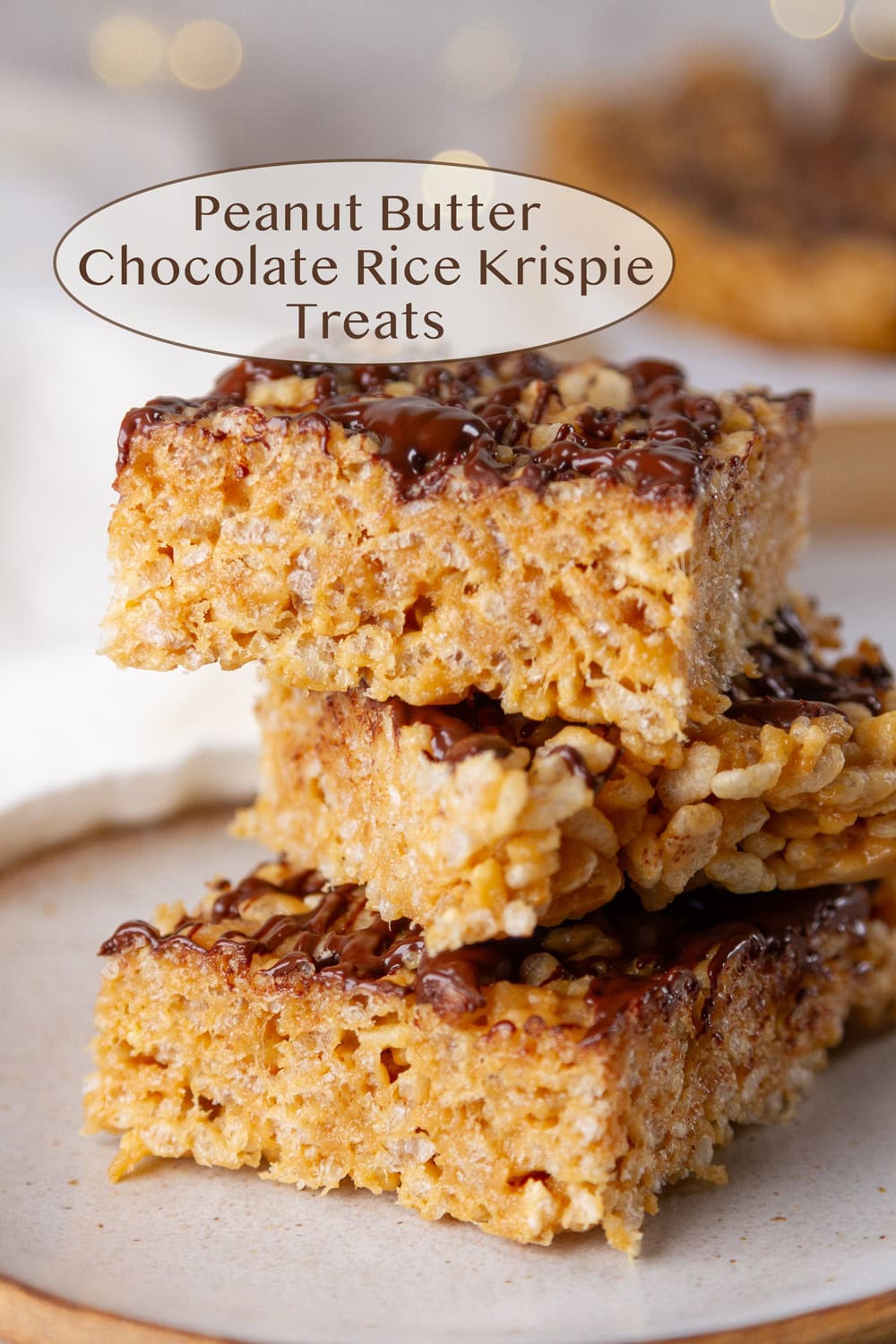 A stack of three Peanut Butter Chocolate Rice Krispie Treats on a white plate.