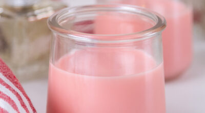 two glass jars filled with pink syrup.