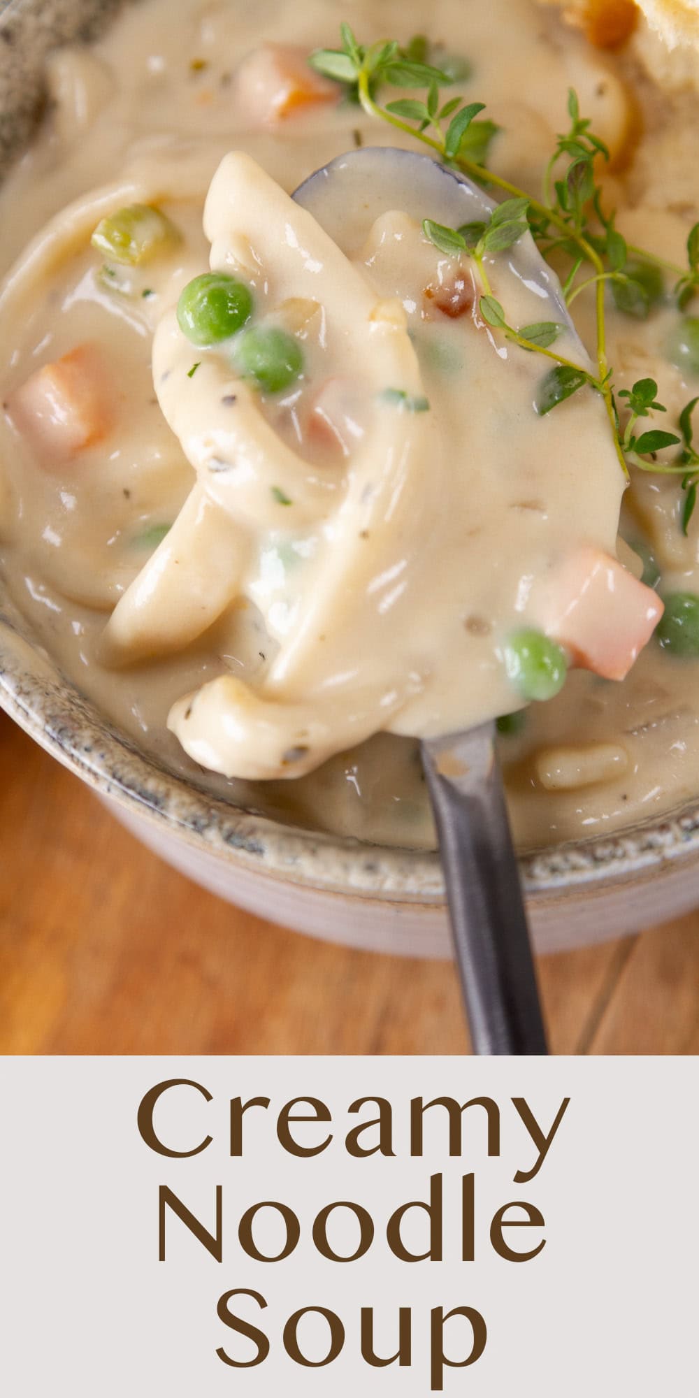 a spoon taking a serving of creamy noodle soup out of a bowl.