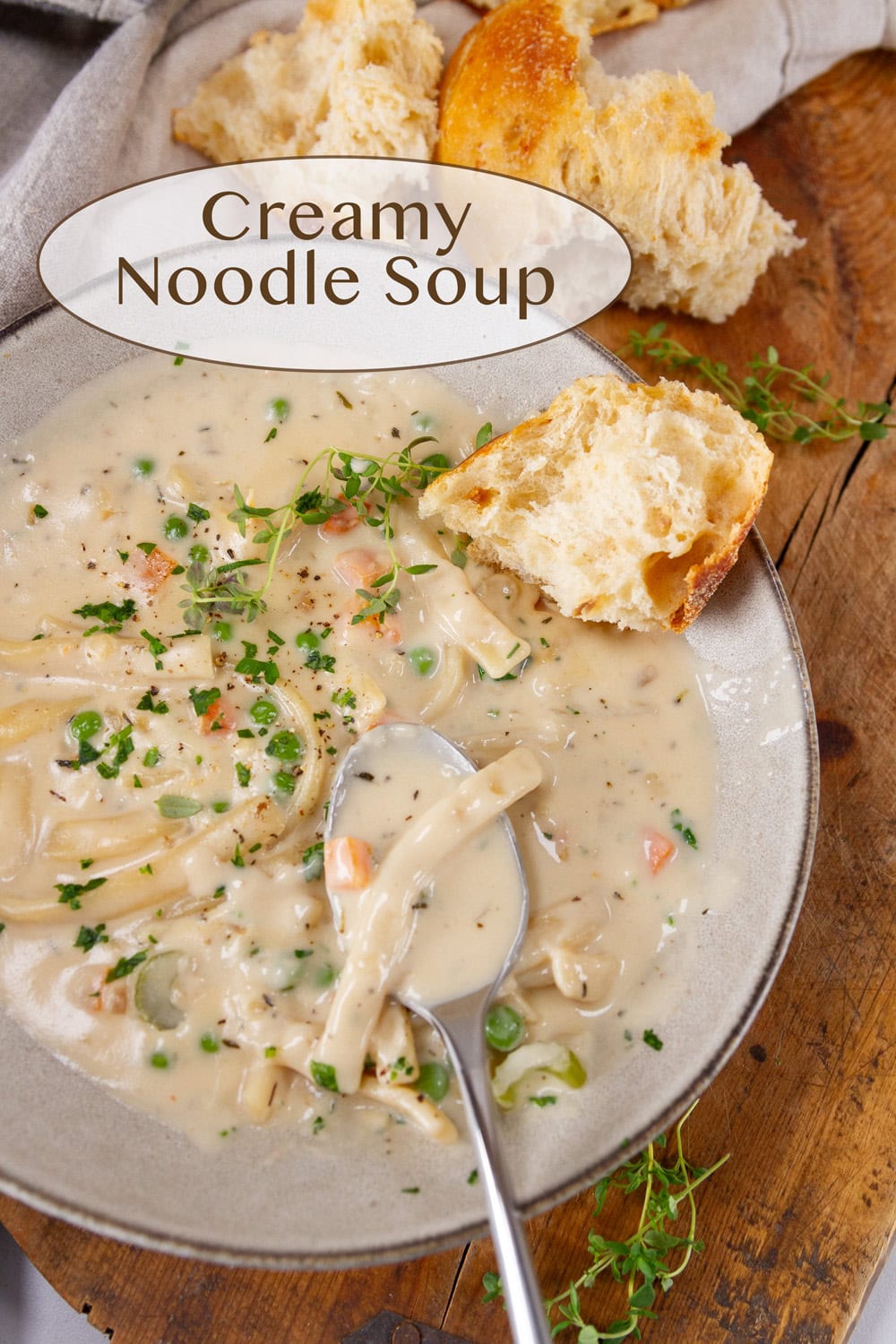a bowl of soup with a piece of crusty bread and a spoon in it.