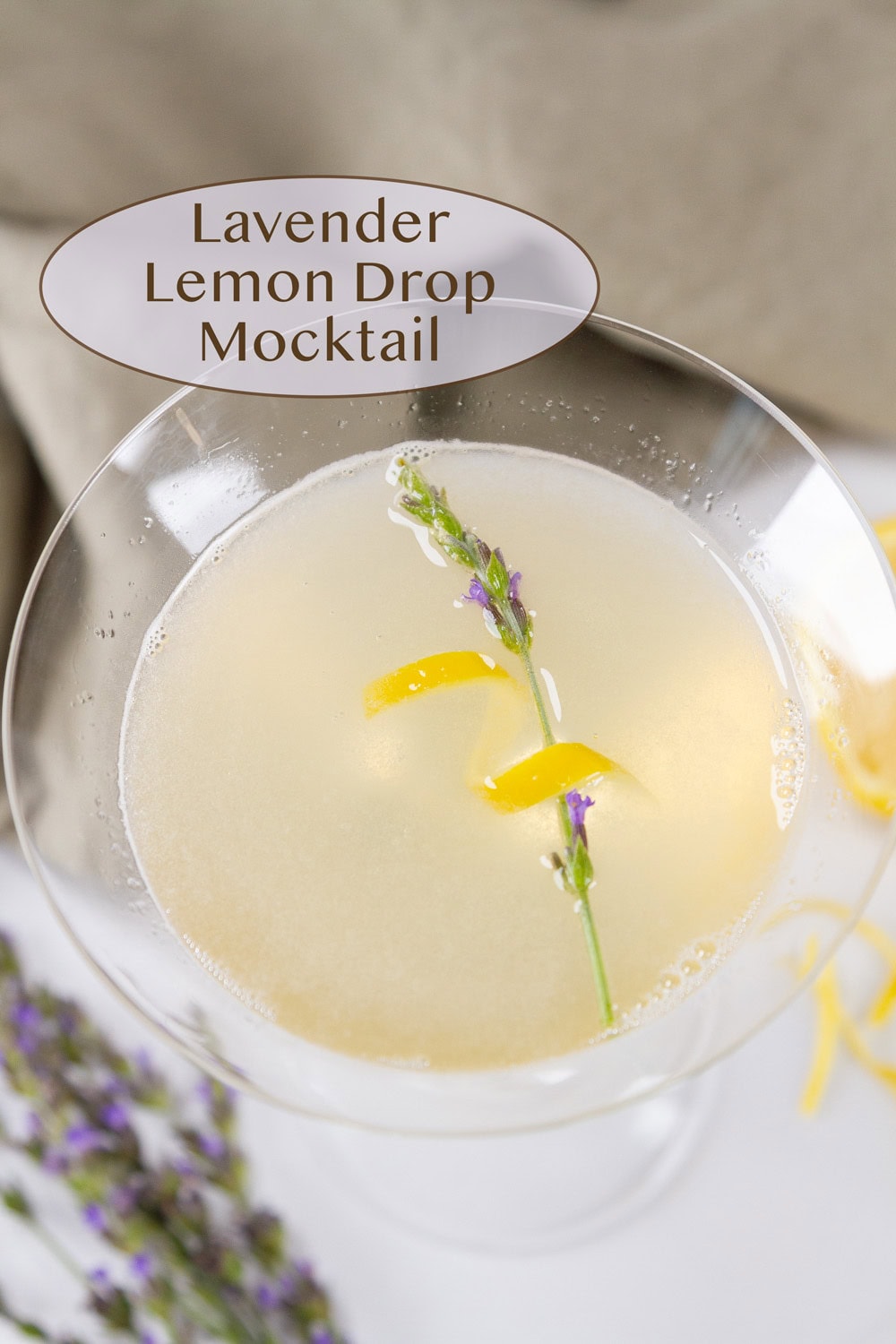 looking down into a glass of lemon drink with lavender and lemon twist.